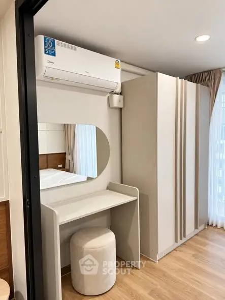 Modern bedroom with sleek air conditioning and stylish vanity in a bright, airy space.