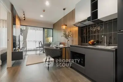 Modern open-layout kitchen and living room with stylish decor and natural light.