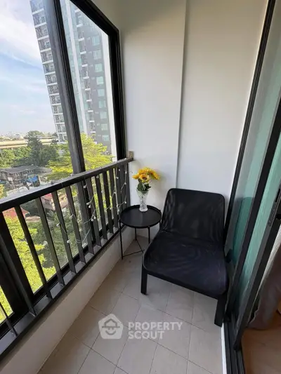 Charming balcony with city view, cozy seating, and decorative flowers, perfect for relaxation.
