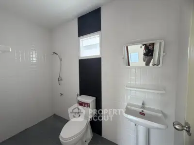 Modern bathroom with sleek white tiles and compact fixtures, ideal for contemporary living spaces.