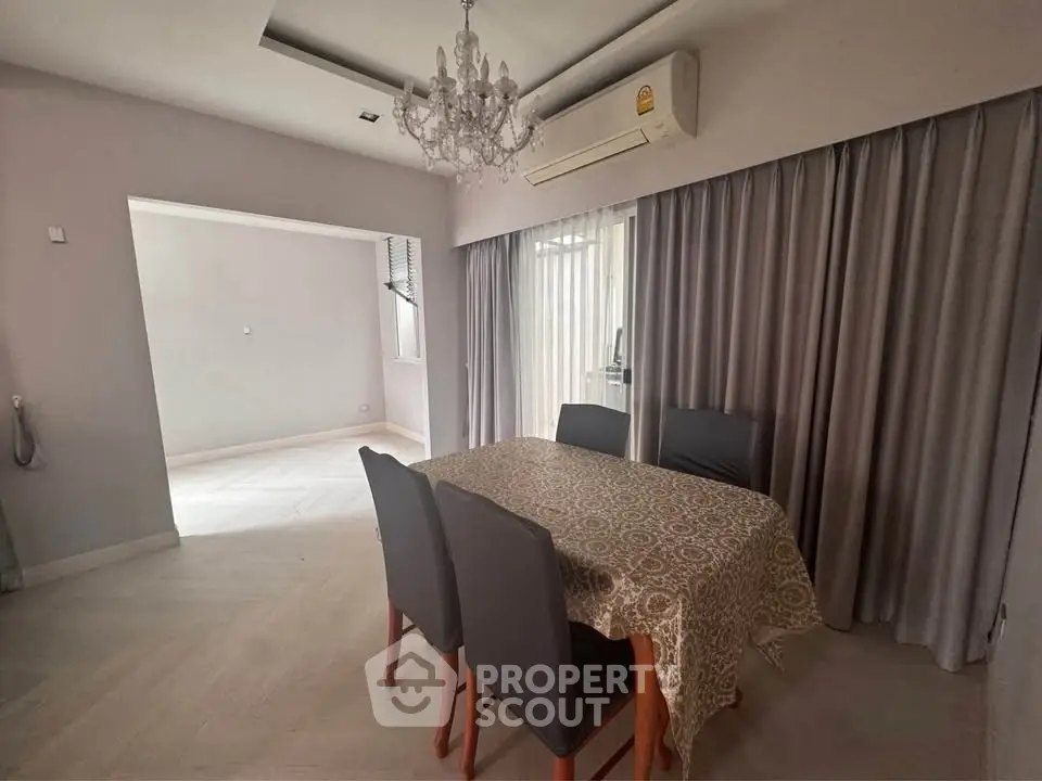 Elegant dining area with chandelier and air conditioning in modern apartment