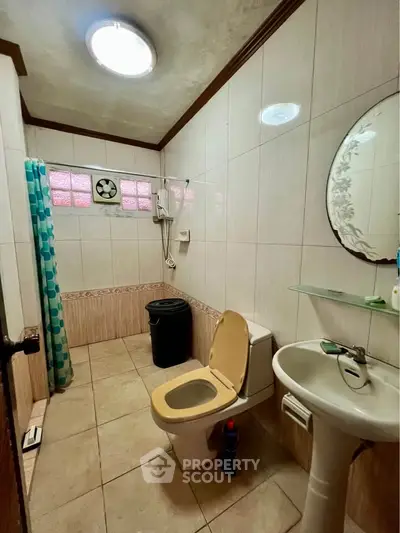 Cozy bathroom with tiled walls and modern fixtures in a real estate property.