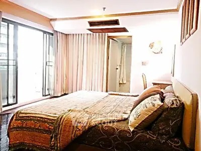 Spacious bedroom with large windows and elegant decor in a modern apartment.