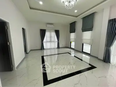 Spacious living room with elegant marble flooring and high ceilings, featuring large windows and modern curtains.