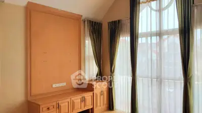 Spacious room with large windows and elegant curtains, perfect for natural light lovers.