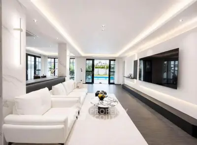 Luxurious modern living room with elegant white sofas, marble coffee table, and pool view through large windows.