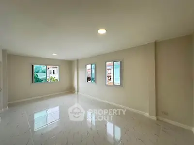Spacious empty living room with large windows and glossy tiled floor
