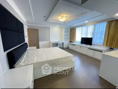 Spacious modern bedroom with large windows and elegant furnishings.
