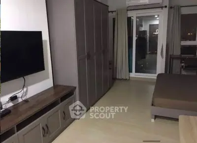 Modern bedroom with sleek furniture and balcony access in urban apartment