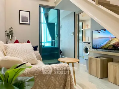 Modern living room with cozy decor and in-unit washing machine, perfect for urban living.