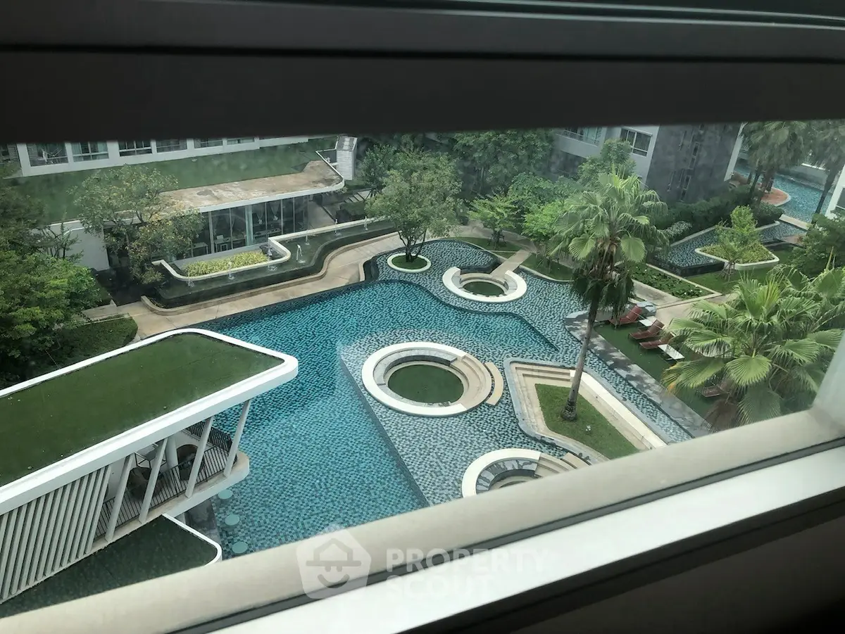 Luxurious modern apartment complex with stunning pool view and lush greenery.