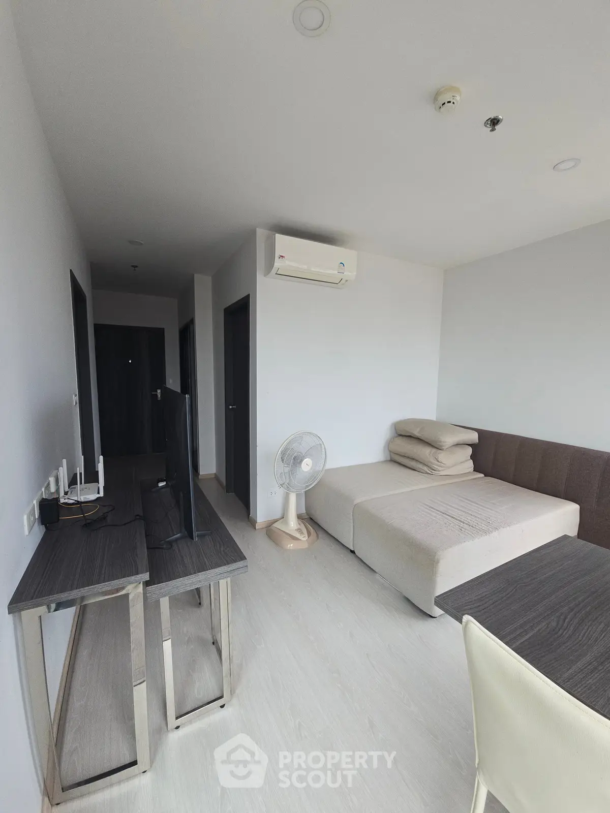 Modern living room with minimalist furniture and air conditioning in a bright apartment.
