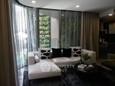 Luxurious modern living room with elegant decor and large windows overlooking greenery.