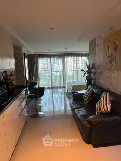 Modern open-plan living room with sleek kitchen and balcony view