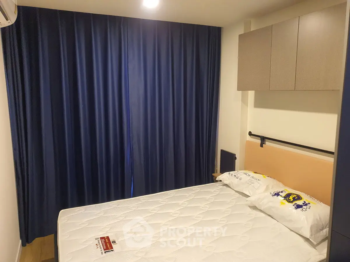 Cozy bedroom with blue curtains and modern storage cabinets, perfect for restful nights.