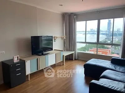 Spacious living room with large window offering stunning river view