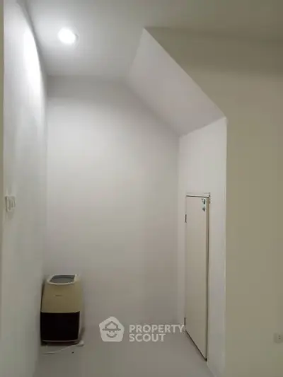 Minimalist storage room with white walls and compact design, perfect for organizing essentials.