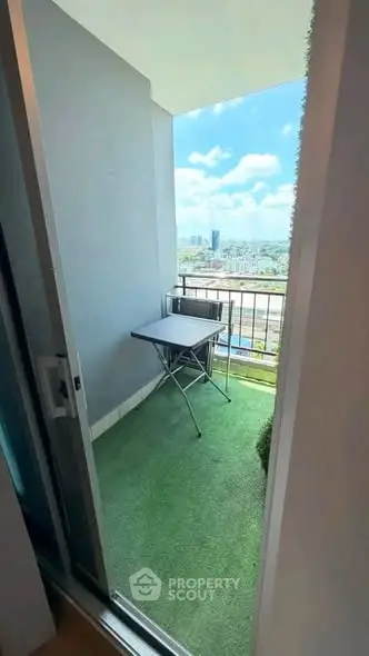 Charming balcony with artificial grass and city view, perfect for relaxation and enjoying the outdoors.