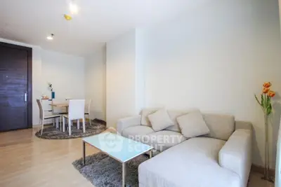 Modern living room with cozy sofa and dining area, bright and inviting space.