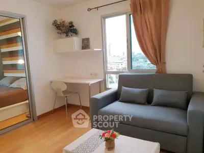 Cozy living room with sofa, desk, and city view window in modern apartment.