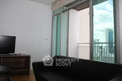 Modern living room with city view and balcony access in high-rise apartment.