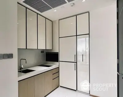 Modern kitchen with sleek cabinetry and integrated appliances in a contemporary apartment.