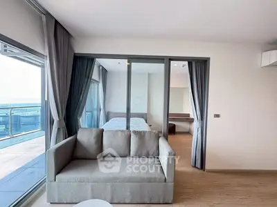 Modern living room with large windows and balcony view in a stylish apartment.