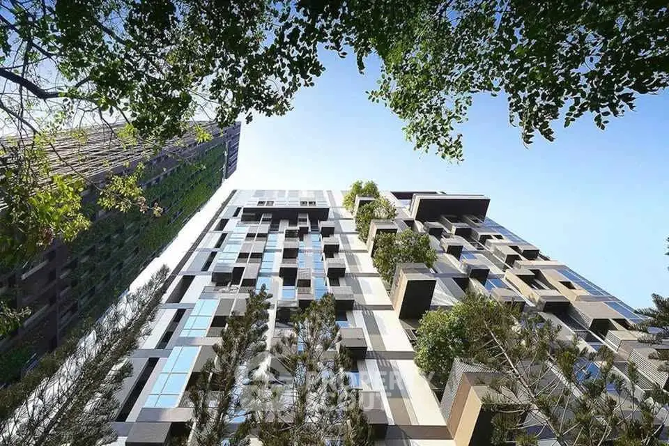 Stunning modern building exterior with lush greenery and unique architectural design.