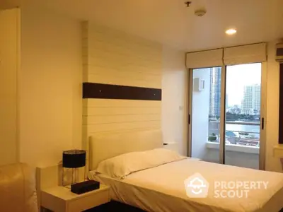 Modern bedroom with city view and balcony access in high-rise apartment.