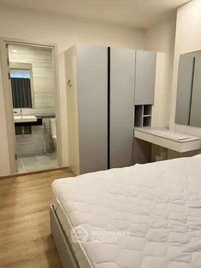 Modern bedroom with ensuite bathroom and sleek wardrobe design.