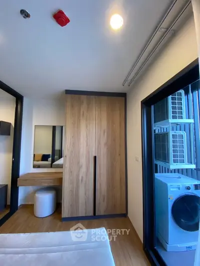 Modern bedroom with wooden wardrobe and washing machine in a cozy apartment.