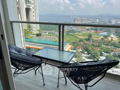 Stunning balcony view with modern seating overlooking cityscape and pool, perfect for relaxation.