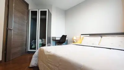Modern bedroom with cozy bed, sleek wardrobe, and stylish desk in a bright interior.