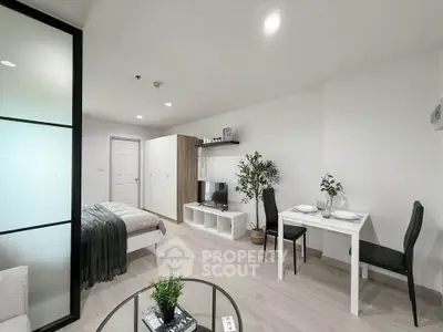 Modern studio apartment with sleek furnishings and open layout, featuring a cozy bed, dining area, and stylish decor.