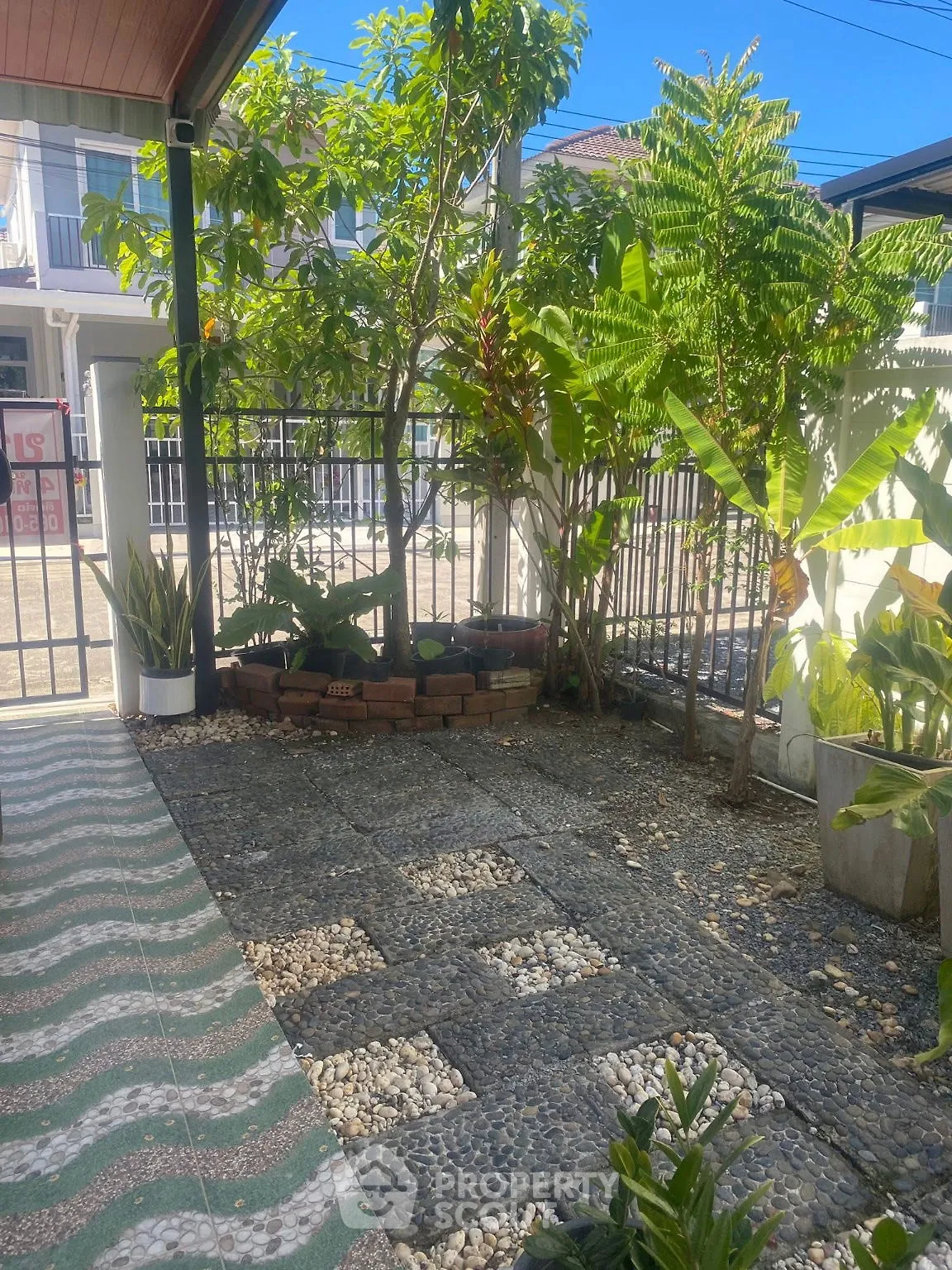 Charming garden area with lush greenery and paved stone pathway in a residential setting.