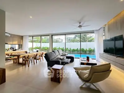 Spacious modern living room with pool view, elegant furniture, and large windows for natural light.