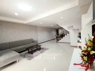 Spacious modern living room with sleek design and elegant staircase