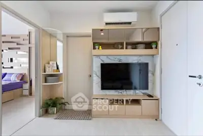 Modern living room with sleek TV unit and open view to bedroom, showcasing stylish interior design.