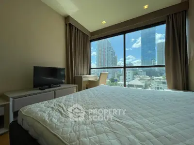 Spacious bedroom with large window offering stunning city views, featuring a cozy bed and modern TV setup.