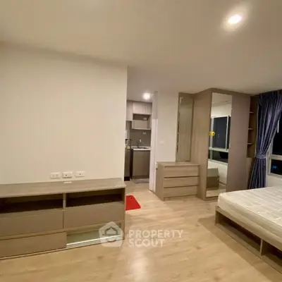 Modern studio apartment with wooden flooring and compact kitchen area