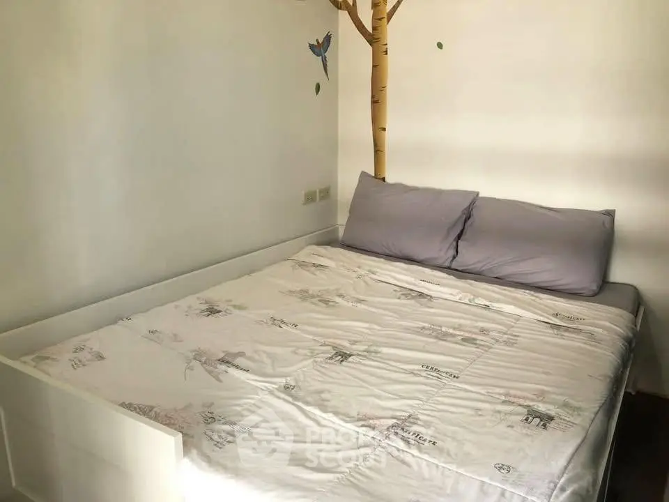 Cozy bedroom with unique tree wall art and comfortable bedding, perfect for relaxation.