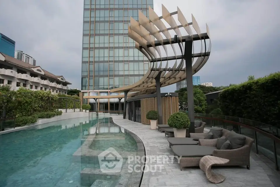 Luxurious poolside area with modern architecture and lush greenery in a high-end residential complex.