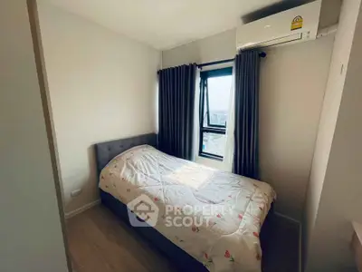 Cozy bedroom with a single bed and window view, featuring modern air conditioning.