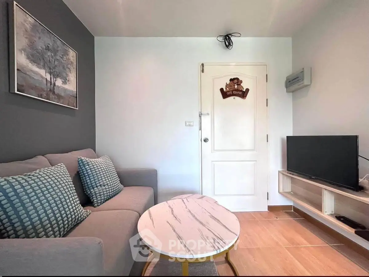 Cozy living room with modern decor and flat-screen TV, perfect for relaxation.