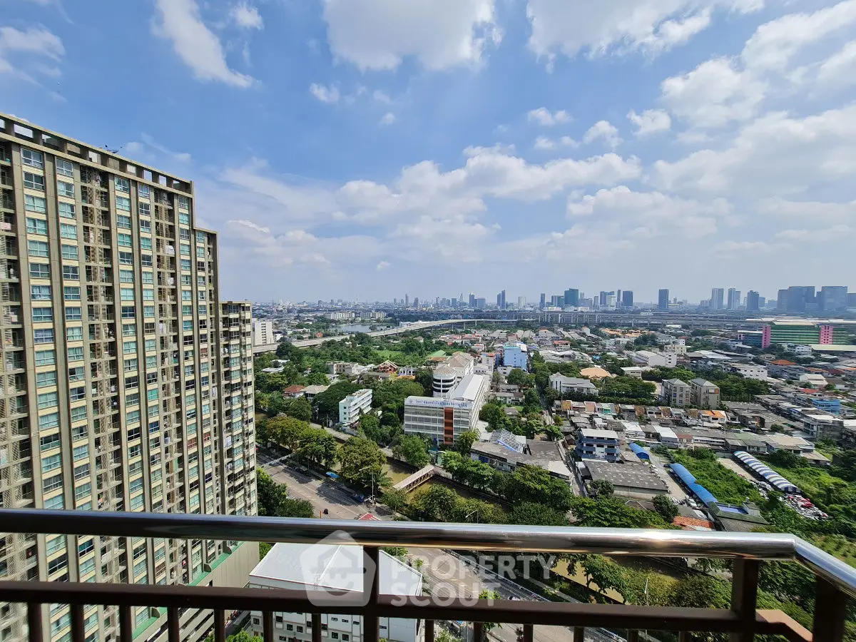 Stunning high-rise cityscape view from a modern balcony, showcasing urban skyline and lush greenery.