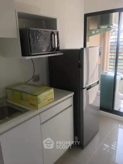 Modern kitchen with sleek appliances and balcony view in a stylish apartment.