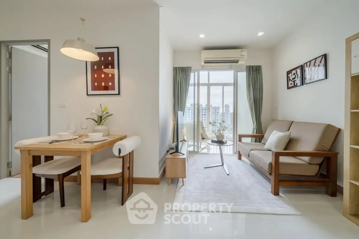 Modern living room with dining area and city view, featuring stylish furniture and natural light.