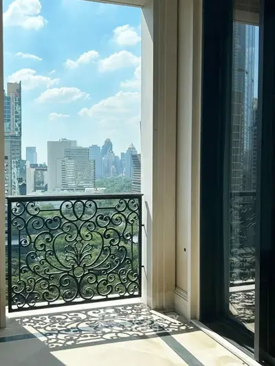Luxurious balcony with ornate railing offering stunning city skyline views and abundant natural light.