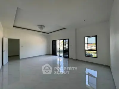 Spacious empty living room with large windows and modern chandelier