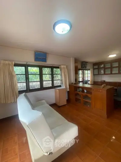 Spacious living room with large windows and elegant wooden furniture